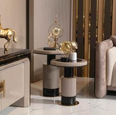 two tables with gold and black accents in a living room