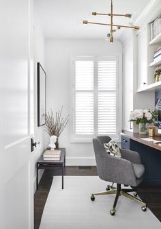 a room with a chair, desk and bookshelf on the wall in it