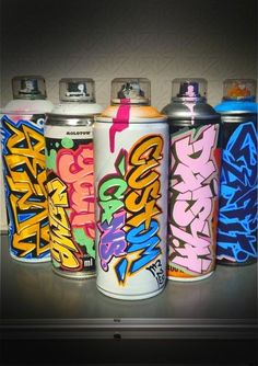 four different types of spray paint cans lined up on top of each other in a row