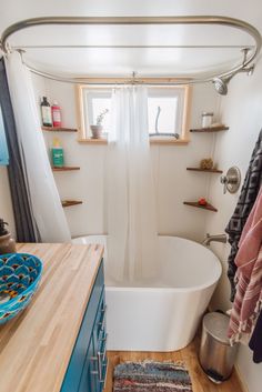 a bathroom with a tub, sink and shelves