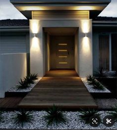 a modern house with lights on the front door and steps leading up to the entrance