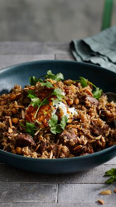 a blue bowl filled with rice and meat