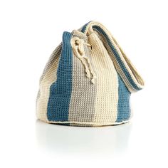 a crocheted bag with blue and white stripes on the inside, sitting on a white surface