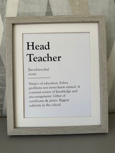 a framed print with the words head teacher in black and white on it, next to a wallpapered background