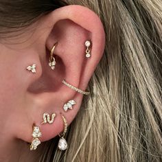 a woman's ear with three different types of piercings