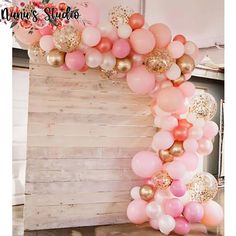 a balloon arch with pink, gold and white balloons