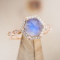 a close up of a ring with a blue stone in the center and diamonds around it