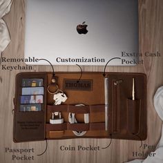 an open laptop computer sitting on top of a wooden table next to a wallet and keychain