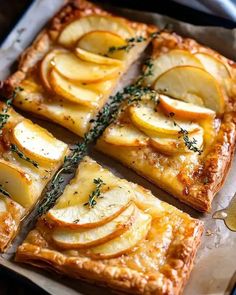 an apple tart is cut into squares and placed on a baking sheet with a serving utensil