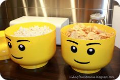 two yellow mugs with faces painted on them are sitting next to a microwave oven