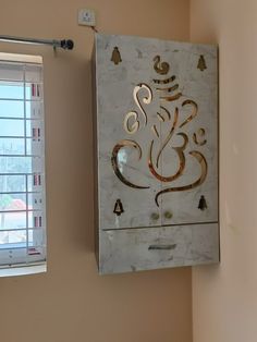 a white and gold wall hanging on the side of a wall next to a window