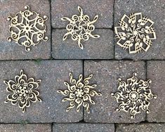 four wooden snowflakes sitting on top of a stone floor next to each other