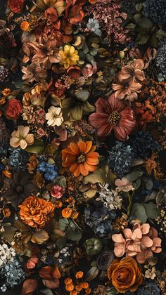 a bunch of flowers that are on the ground in front of a wall with many different colors