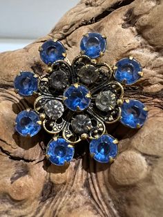 "Elevate your accessory game with this enchanting Vintage Blue Round Flower Rhinestone Brooch Pin, meticulously prong-set for a timeless and elegant look. The stunning blue hue and intricate flower design will effortlessly add a touch of vintage charm to any outfit. Approx Measurements 1.25\" Diameter  Condition: Vintage Excellent.   Sold as is.   PLEASE review all pictures closely.  Contact me with any questions or problems with your order. Thank you for shopping in my store.  International buyers please contact me for shipping details and cost. Most of my items are vintage and used, they will all show some signs of light wear or use.   Major flaws will be noted in the description.  Items are sold \"as is\" so please make sure you look at all pictures carefully.  I have done my best to ca Vintage Blue Brooches For Jewelry Making, Blue Victorian Brooch For Formal Occasions, Victorian Blue Brooch For Formal Occasions, Blue Victorian Brooches For Formal Occasions, Elegant Blue Jeweled Brooches, Vintage Blue Brooch Pin, Vintage Sapphire Brooches For Gifts, Vintage Sapphire Brooches As Gift, Blue Floral Brooch Jewelry