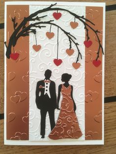 a handmade card with an image of a couple under a tree and hearts hanging from the branches