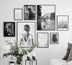 black and white photographs hang on the wall above a couch in a living room with a coffee table