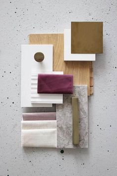 an assortment of different colors and materials on a table with a white wall in the background