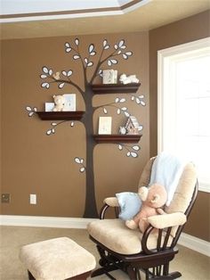 a baby's room with a tree on the wall and shelves in the corner