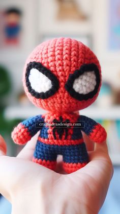 a small crocheted spider - man doll is held in the palm of someone's hand