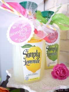 two jars filled with lemonade sitting on top of a table next to a pink flower