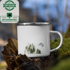 a white coffee cup sitting on top of a moss covered tree stump next to a sign that says top seller recommended