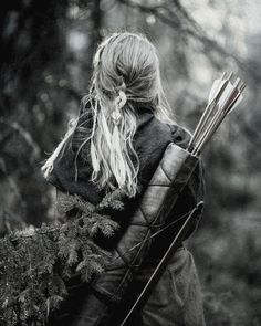 a woman with long hair carrying a bow and arrows