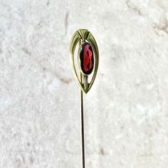 A beautiful antique Art Nouveau garnet stick pin/hat pin brooch crafted in 14 karat yellow gold. It is bezel set with an antique elongated rhodolite garnet cabochon (faceted at back) weighing approximately 1.35 carat. It measures 9.75 x 4.50 mm. Weighs 2.15 grams. L: 2.74" (6.96 cm). W: 0.38" (9.67 mm). The setting part is 0.79” (2 cm) long. Birthstone: January. Condition: Very Good. - 14-day return policy, no questions asked. - Free insured shipping in the US. - International shipping available Elegant Brass Brooches For Collectors, Elegant Brass Brooch For Gift, Pin Hat, Hat Pin, Rhodolite Garnet, Stick Pins, Hat Pins, Pin Brooch, Antique Art