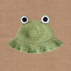 a crocheted frog hat with eyes on it