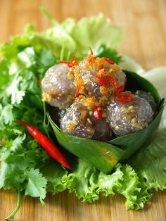 some food is sitting in a bowl on top of lettuce and red peppers