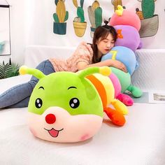 a woman laying on top of a bed next to stuffed animals and cactuses in the background