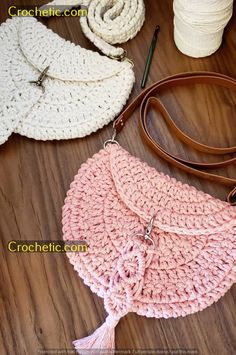 the crocheted purse is sitting next to some yarn