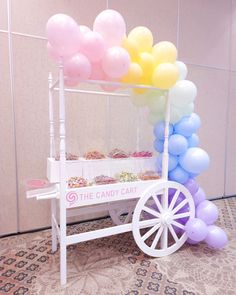 the candy cart is decorated with balloons and streamers