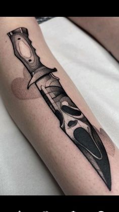 a tattoo with a knife on the arm and an ink pen in the lower half