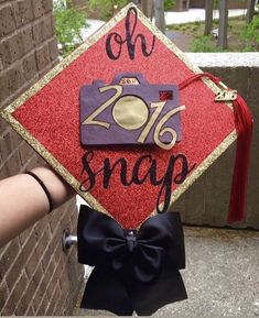 a graduation cap with the words oh snap on it is held by someone's hand