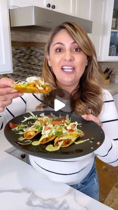 a woman holding a plate with food on it