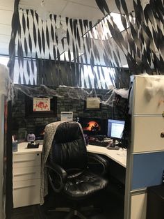 an office cubicle with black and white decor on the walls, desks and chairs