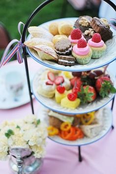 three tiered trays filled with different types of pastries on top of a table