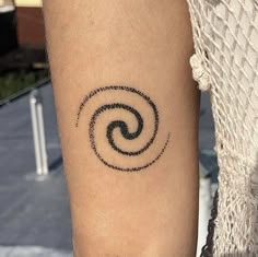 a person with a tattoo on their arm that has an image of a spiral in the middle