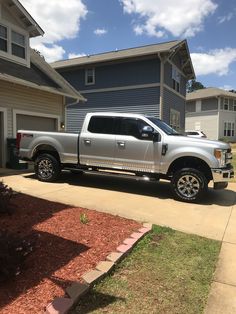 a silver truck parked in front of a house