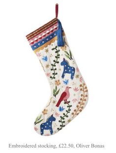 a christmas stocking hanging from the ceiling with birds and flowers on it's side