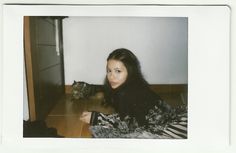 a woman laying on the floor next to a small dog and looking at the camera