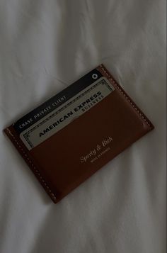 a brown leather credit card holder on top of a white sheet with the name american airlines