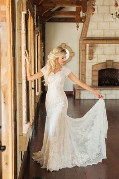 a woman in a wedding dress is posing for the camera