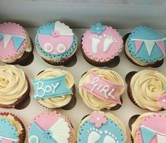 a box filled with cupcakes covered in frosting and decorated to look like baby shower items