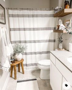 a bathroom with a white toilet sitting next to a bath tub under a shower curtain