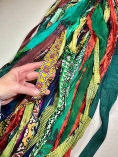 a person is holding onto an assortment of scarves