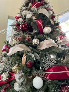 a christmas tree decorated with red, silver and white ornaments