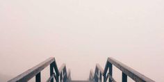 a person walking down a bridge in the fog