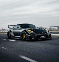 a black sports car driving down the road