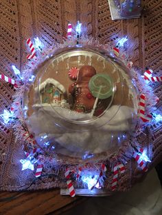 a glass bowl filled with candies and candy canes on top of a table